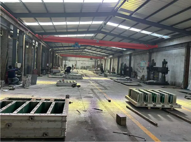 Mold assembly bay with overhead cranes and mold bodies on the floor